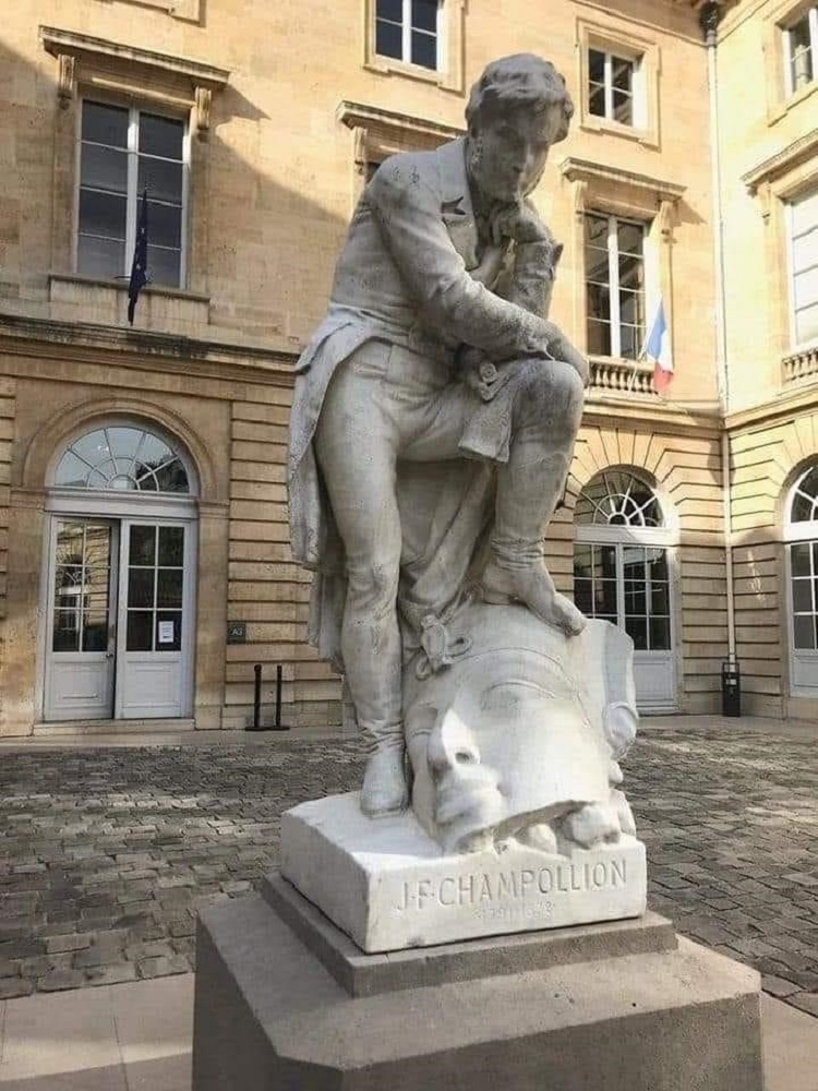  تمثال يُظهر شامبليون وهو يضع إحدى قدميه على رأس حجري لأحد الفراعنة أمام جامعة السوربون في باريس