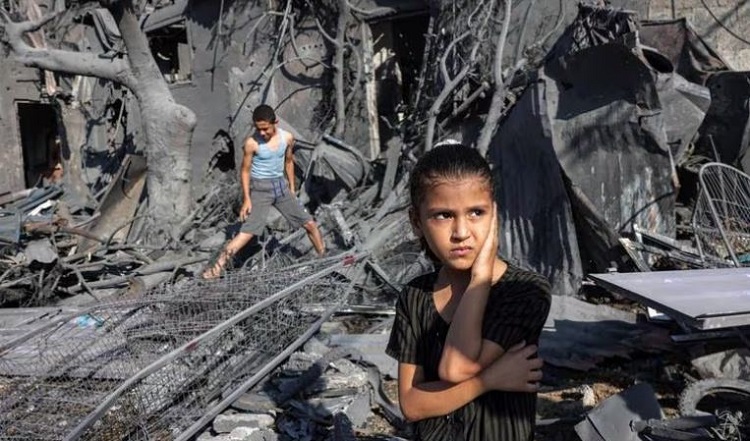 فتاة تقف بجانب الأنقاض خارج مبنى تعرض للقصف الإسرائيلي في رفح، غزة